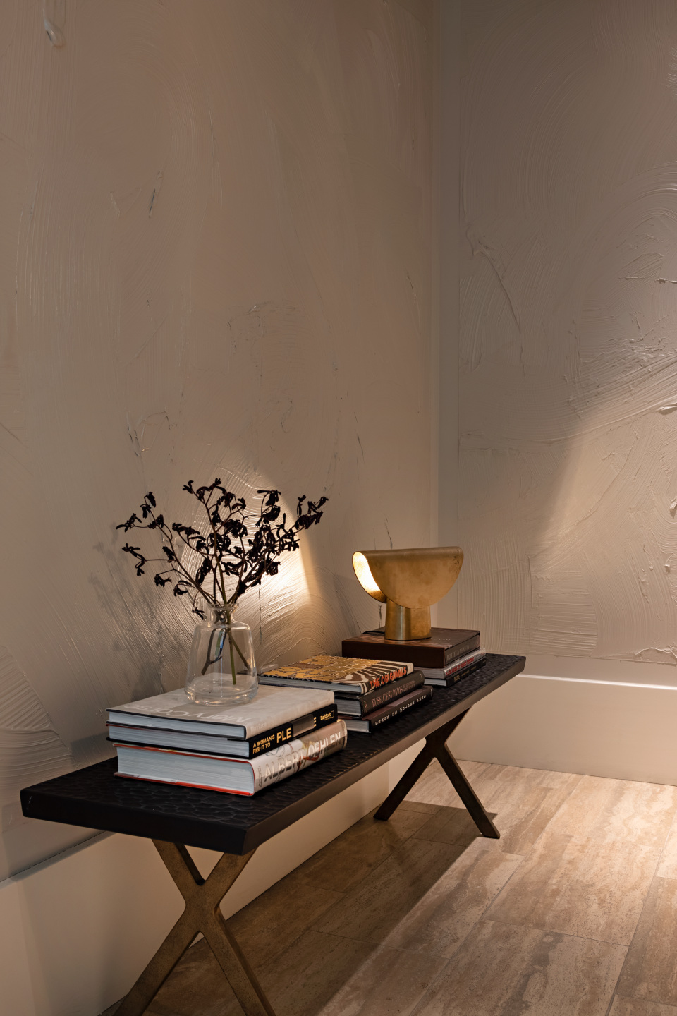 long wooden table in foyer space with books and plant