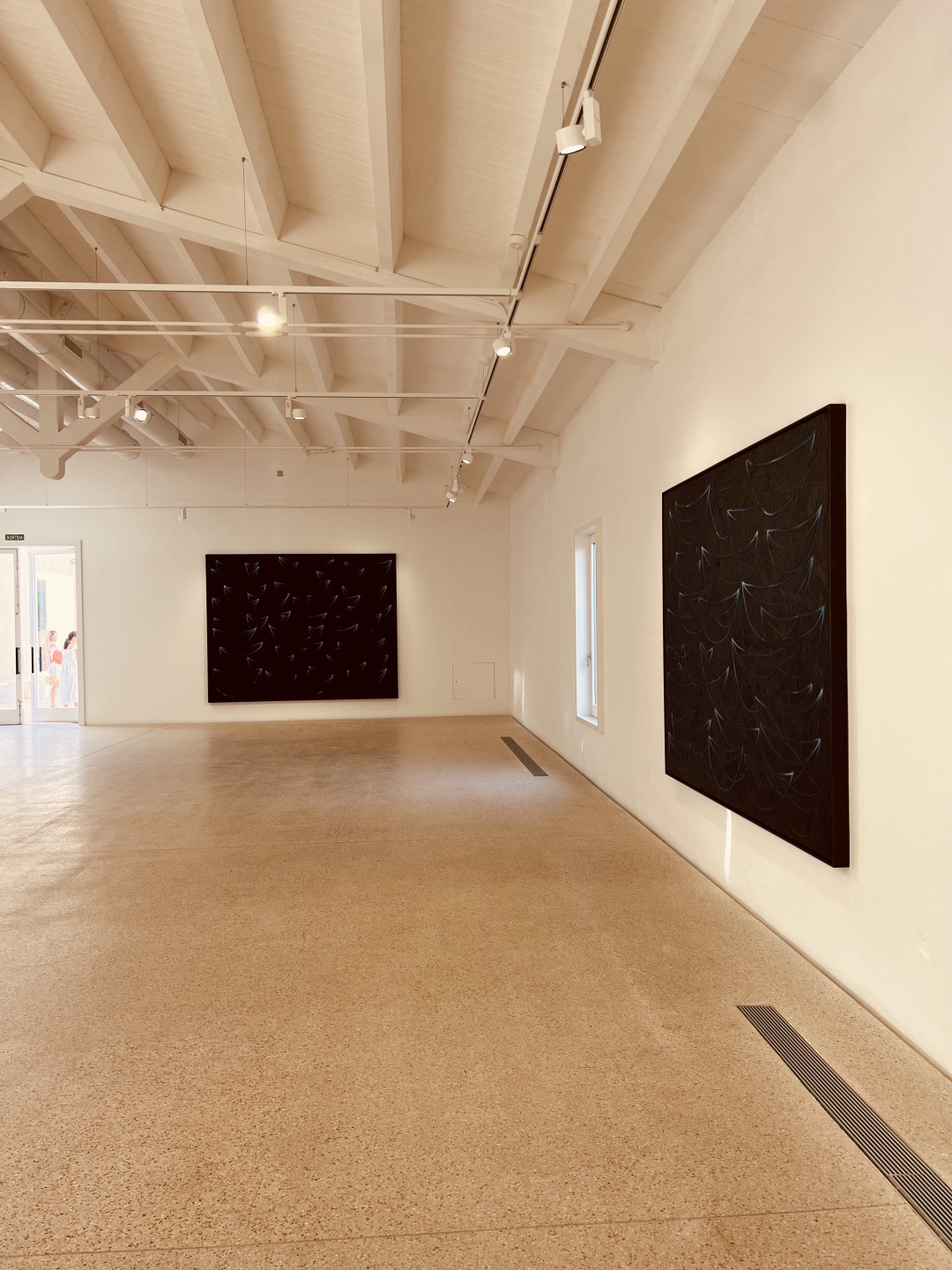 Two paintings in a gallery.