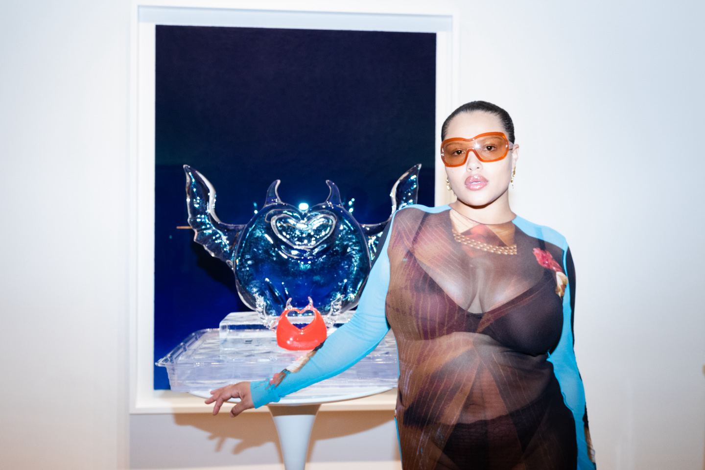 A woman standing in front of an ice sculpture.