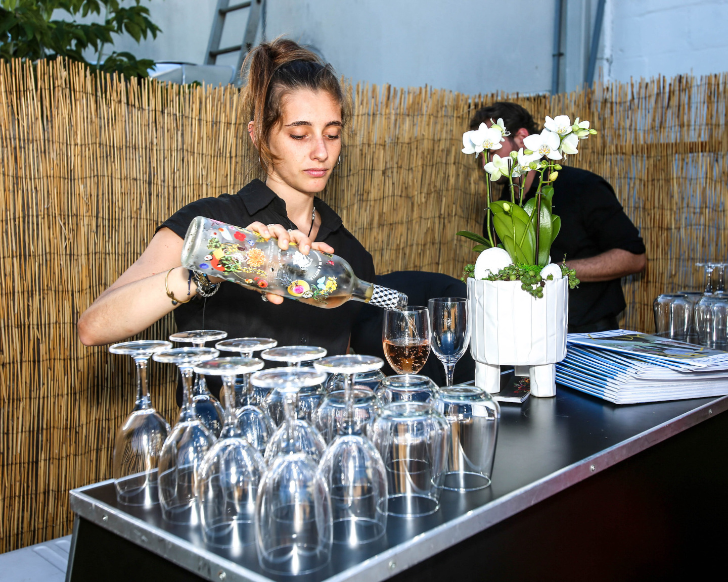 bartender pours glasses of rose