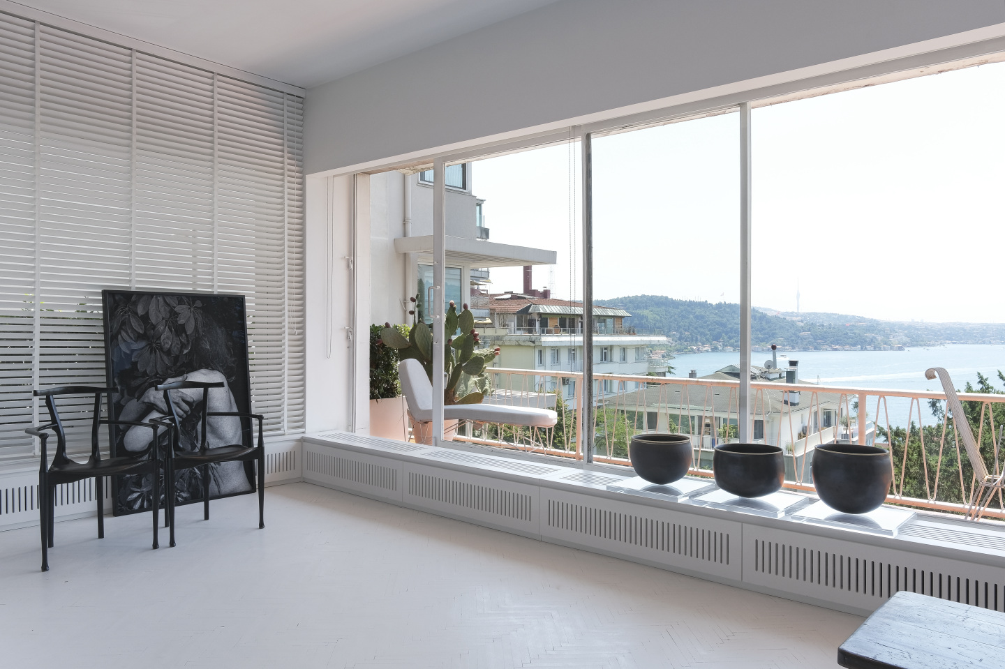A photo and ceramic art pieces installed in a room overlooking the ocean.