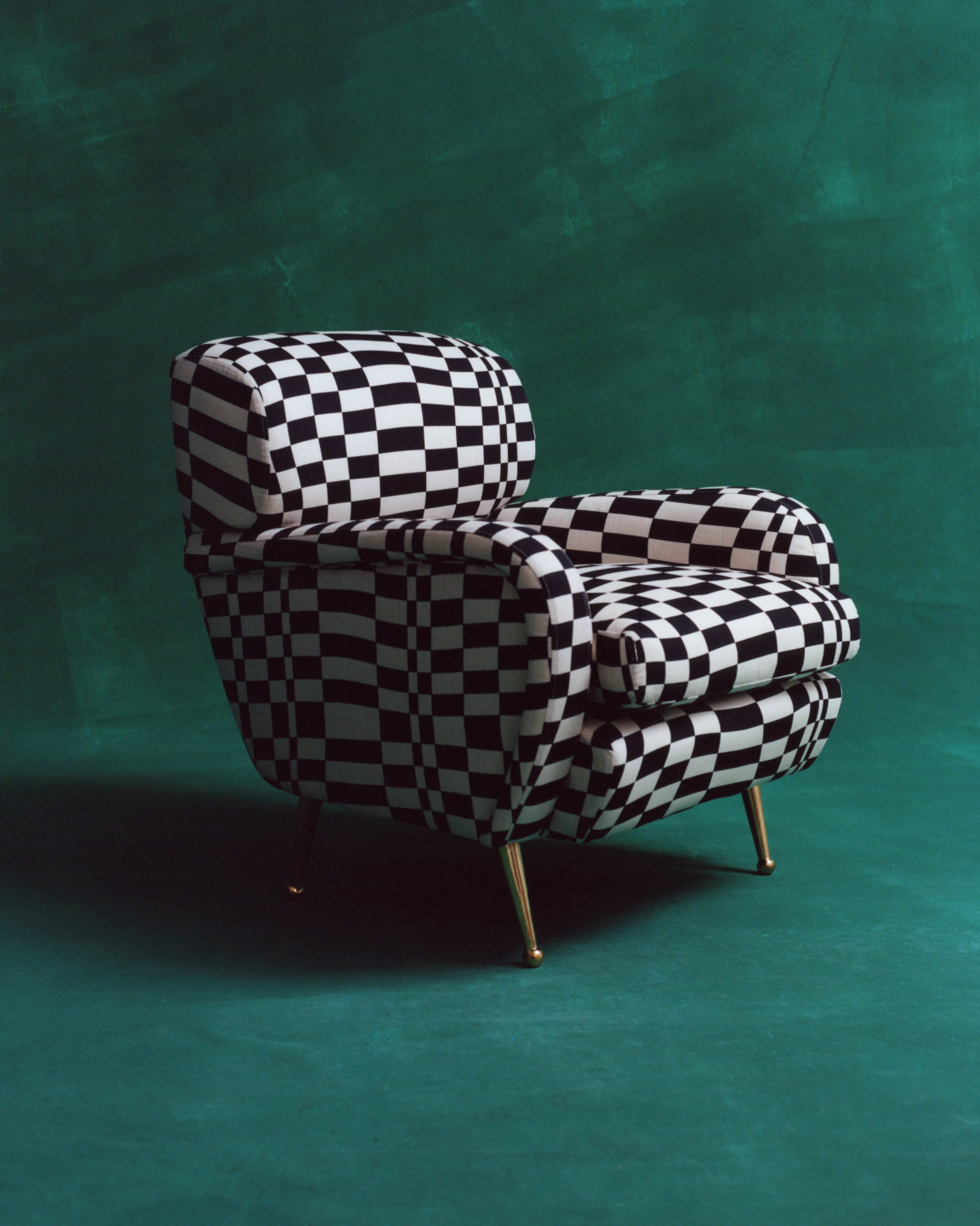 Black and white checkered arm chair against a dark green backdrop