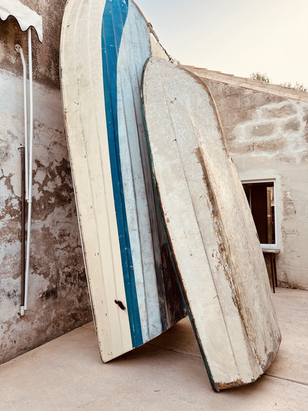 Two row boats against a wall.