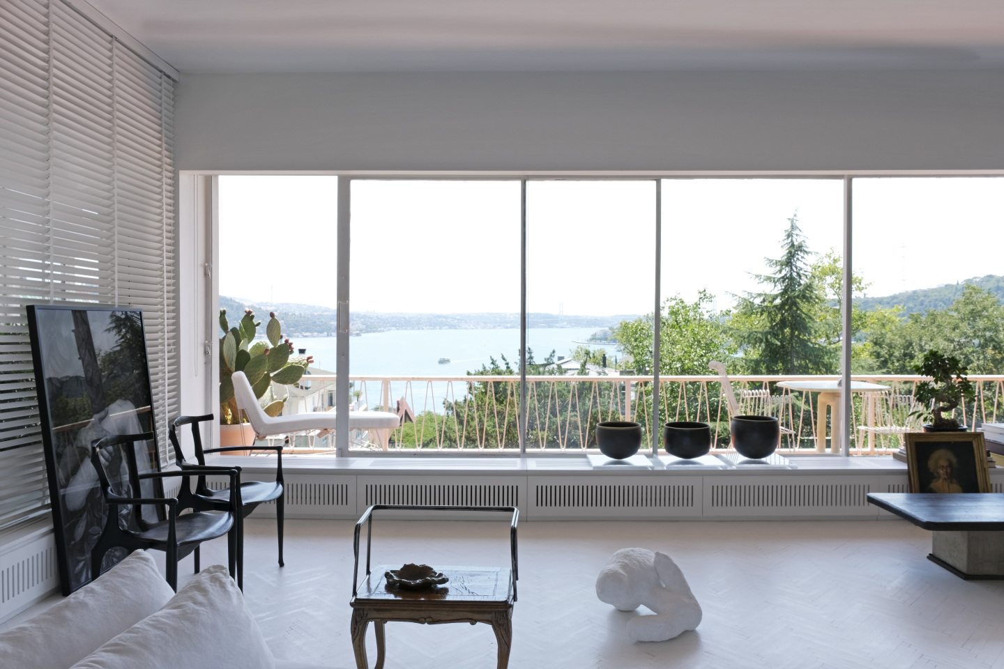 A photo and ceramic art pieces installed in a room overlooking the ocean.