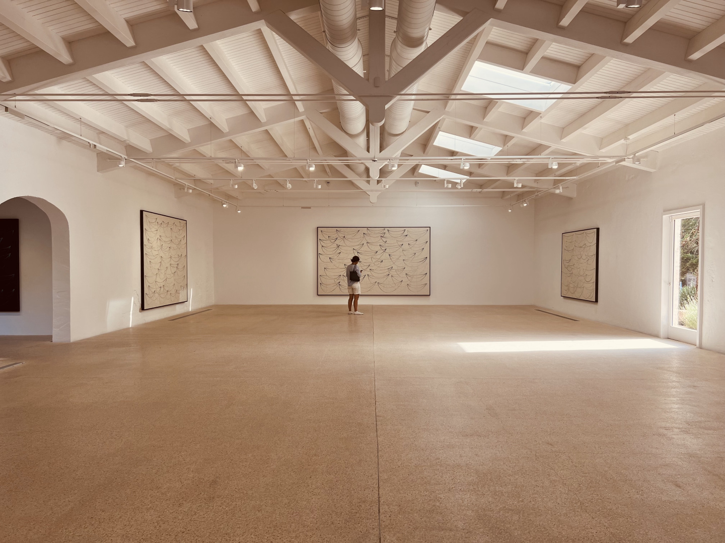 Man standing in a large gallery.