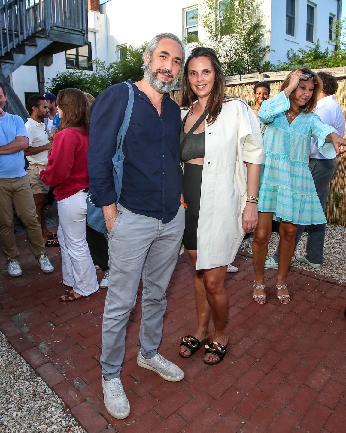 couple poses for photo at outdoor gallery party