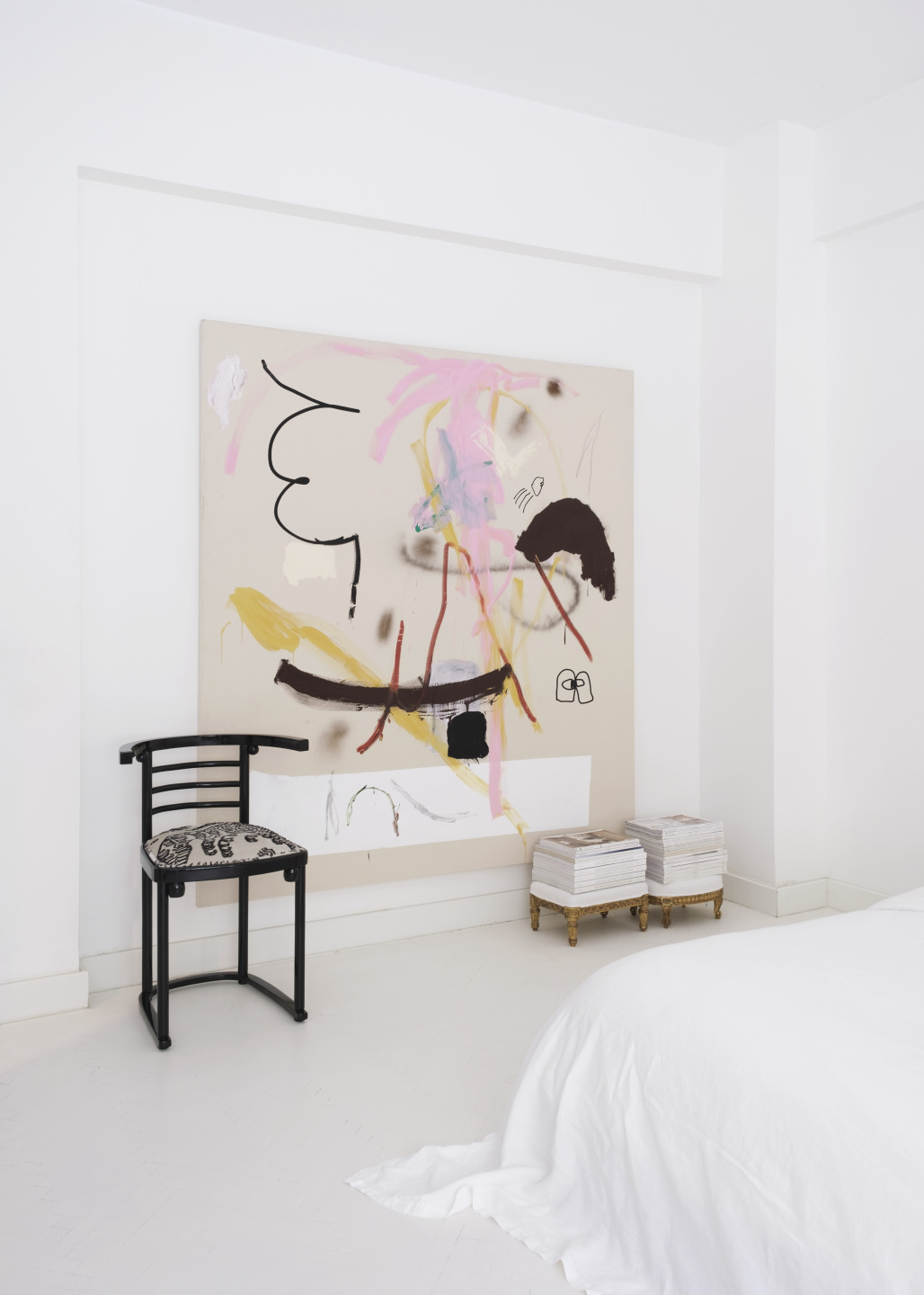 Abstract painting hanging on the wall in a bedroom.