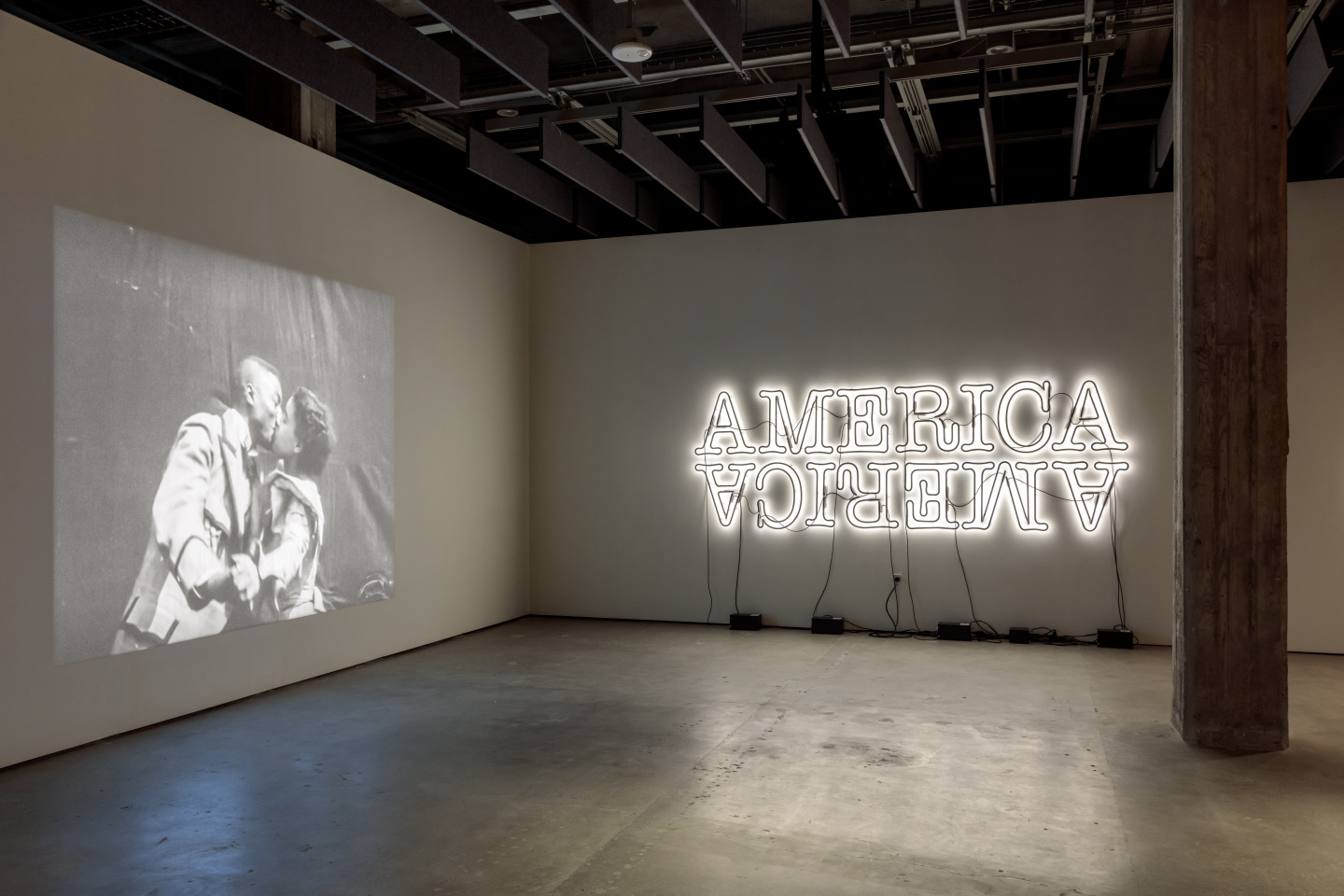 Installation view in the museum projecting a Black film and neon sign saying America.