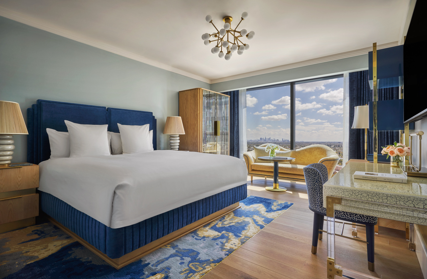 A large hotel room with a view of Los Angeles.