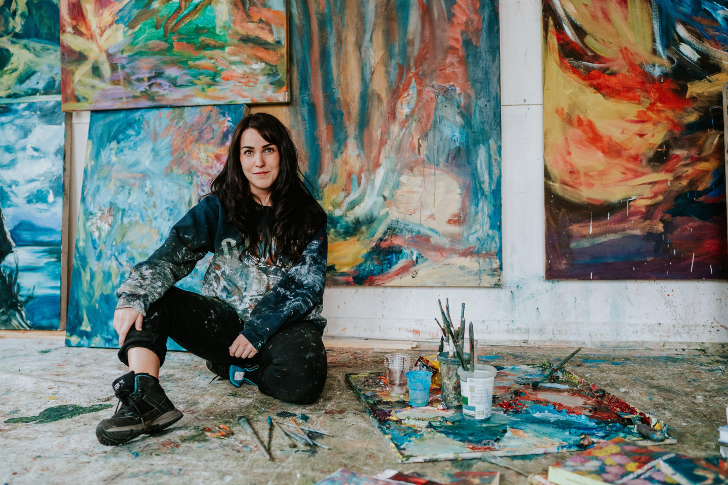 artist in studio with paintings