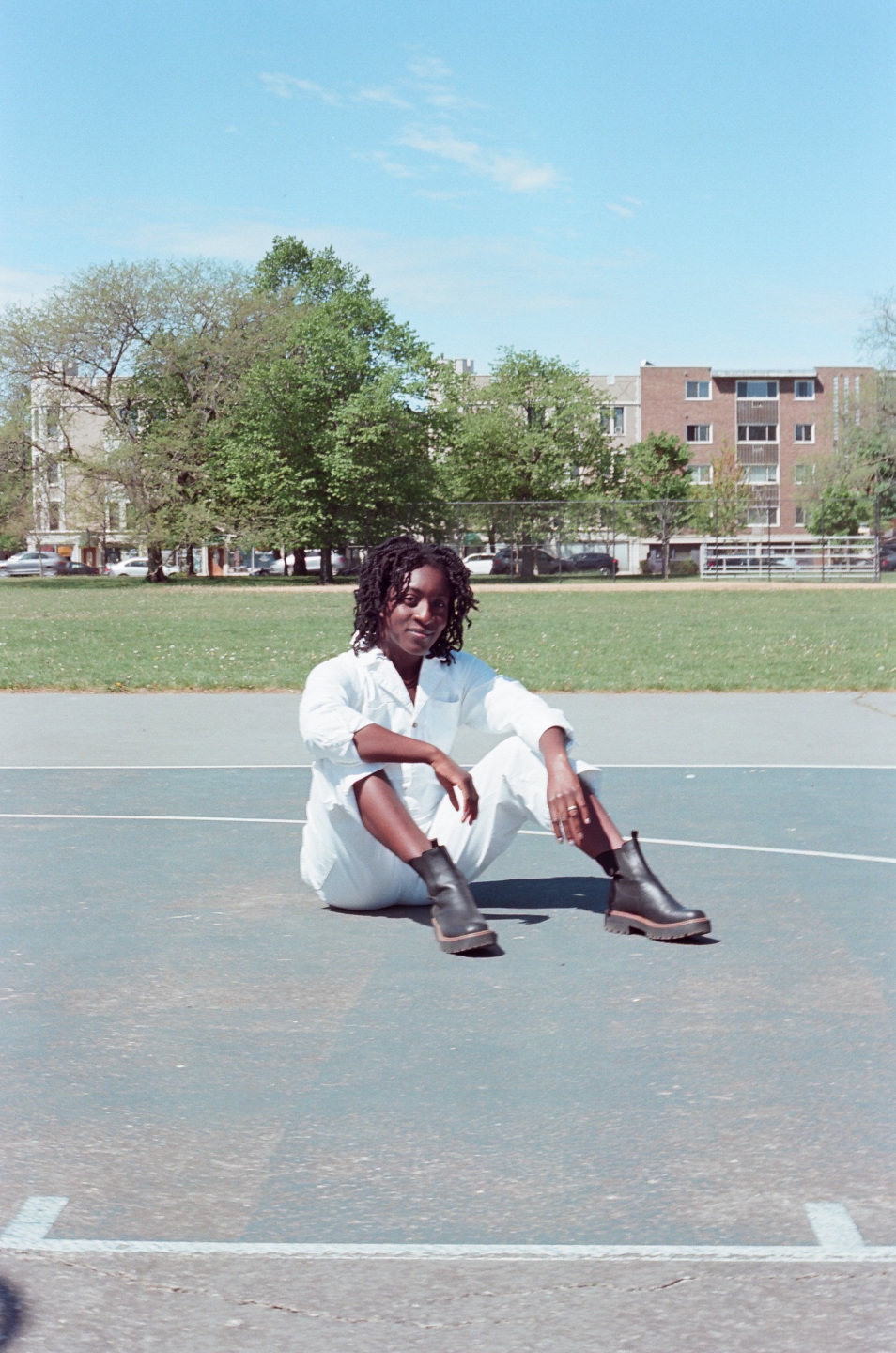 Woman in white sits on basketball court