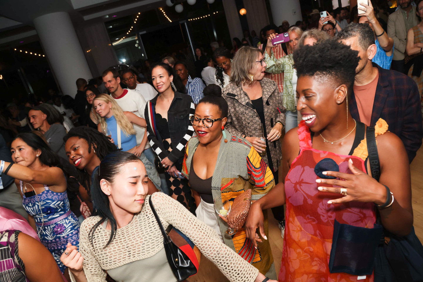 A crowd of people dancing and smiling.