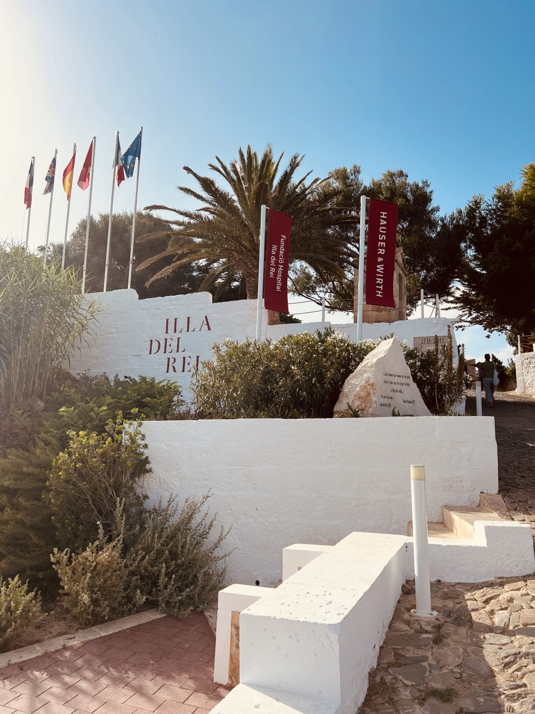 Exterior of White walls, trees, and flags.