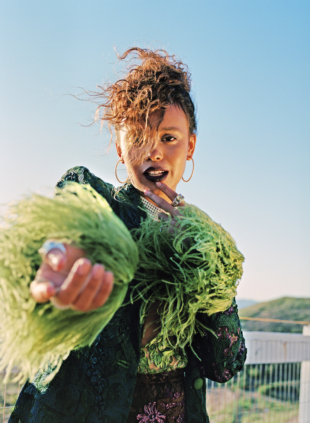 woman in feathery suit pointing at camera