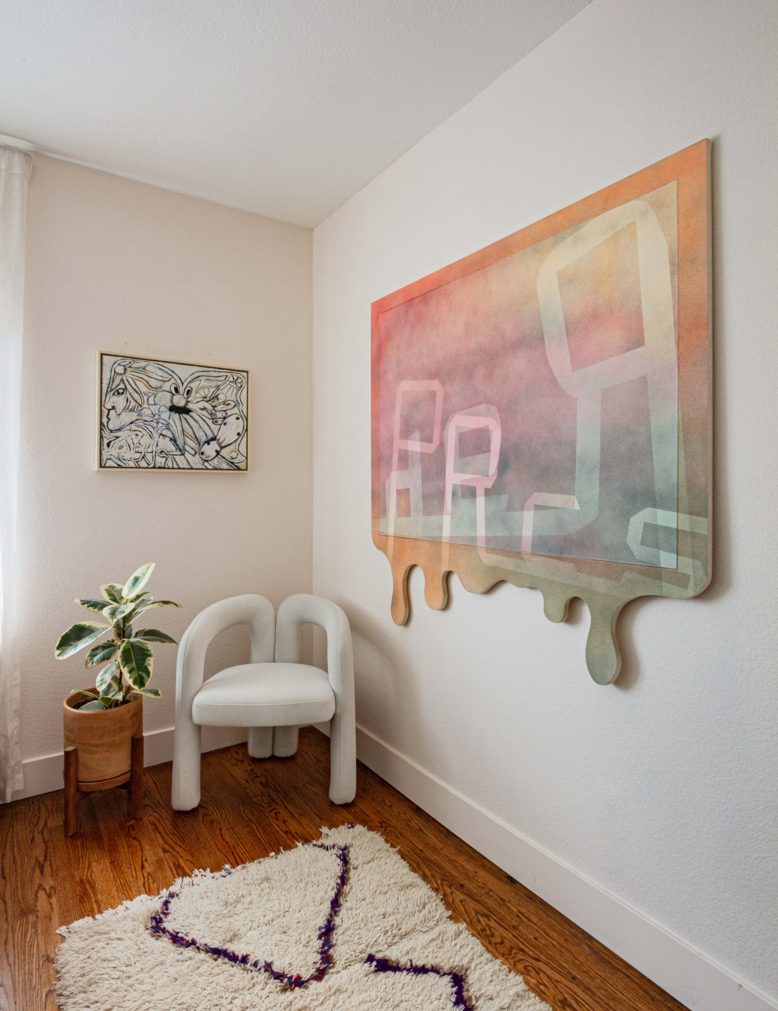 Paintings hanging on the walls above a chair.