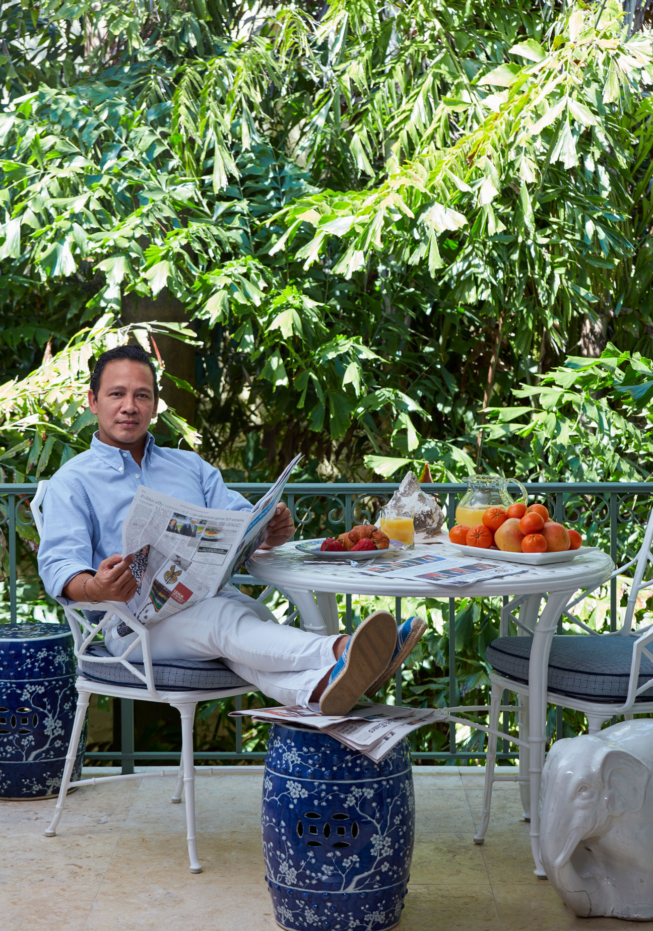 Man sits in chair with feet on ottoman in the outdoors