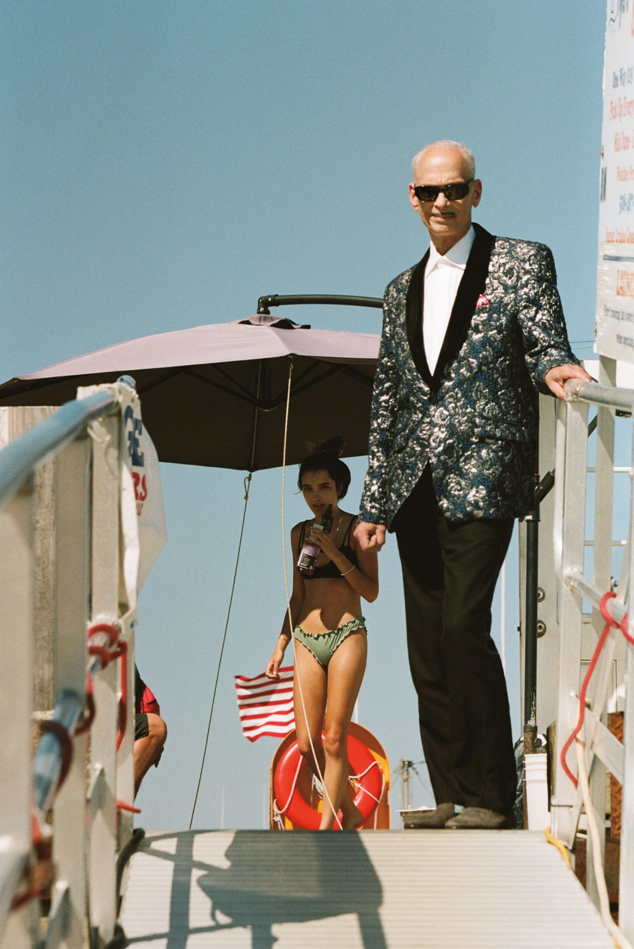 A man standing on a dock with a woman behind him.