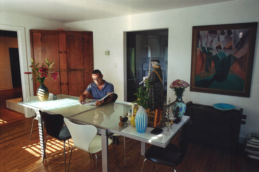 man at table surrounded by art
