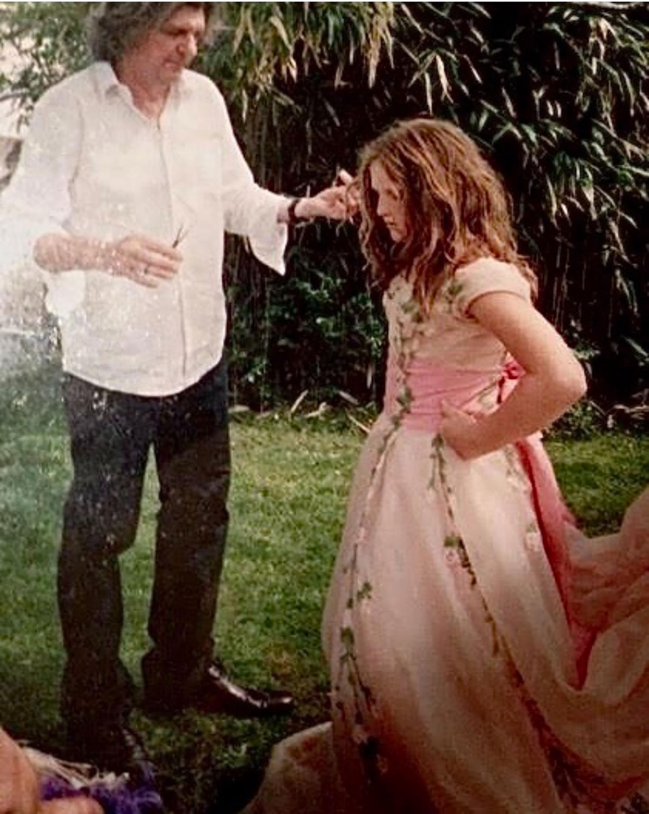 Man stands beside woman in a pink dress