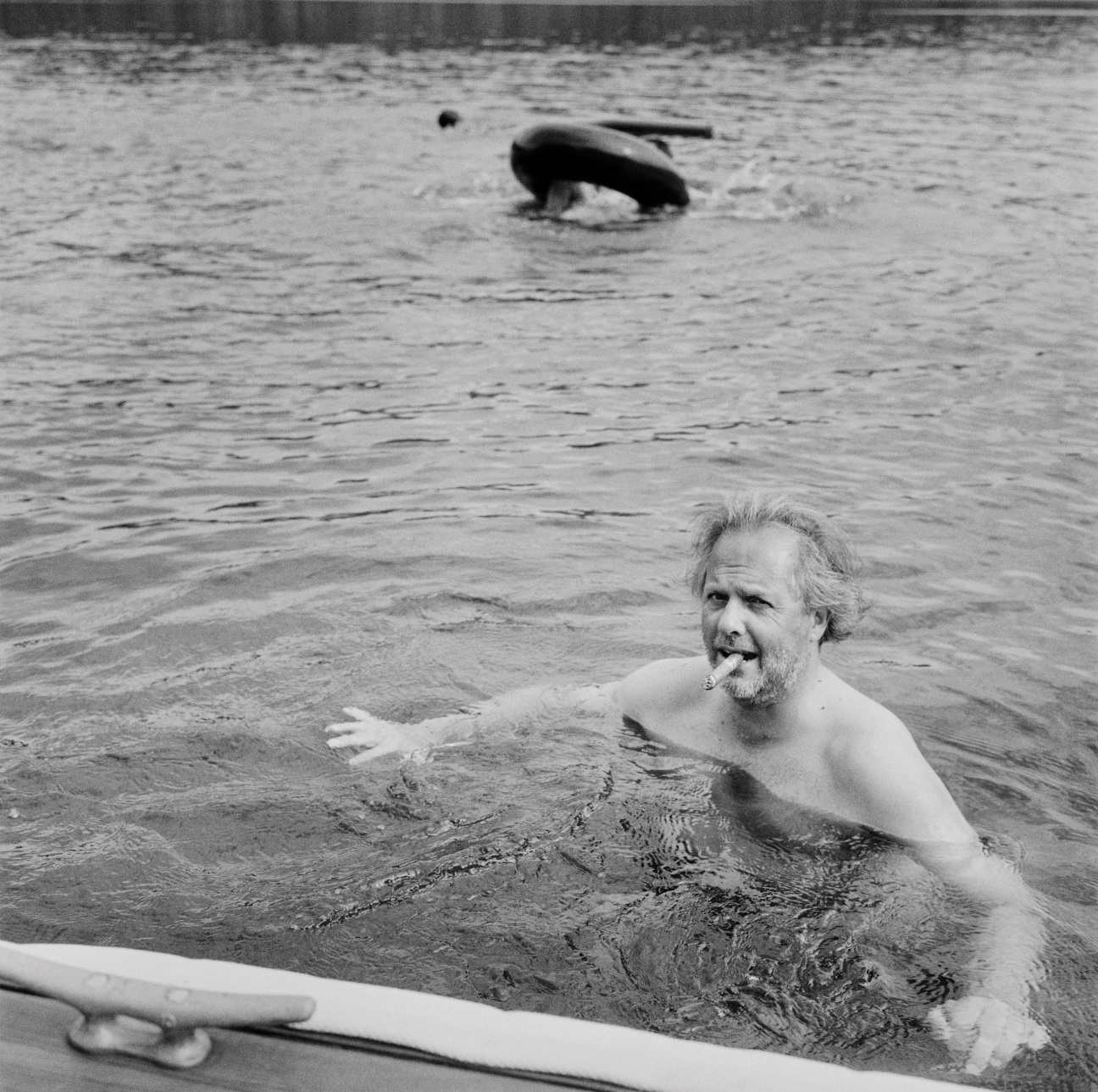 A man in the water smoking a cigar.