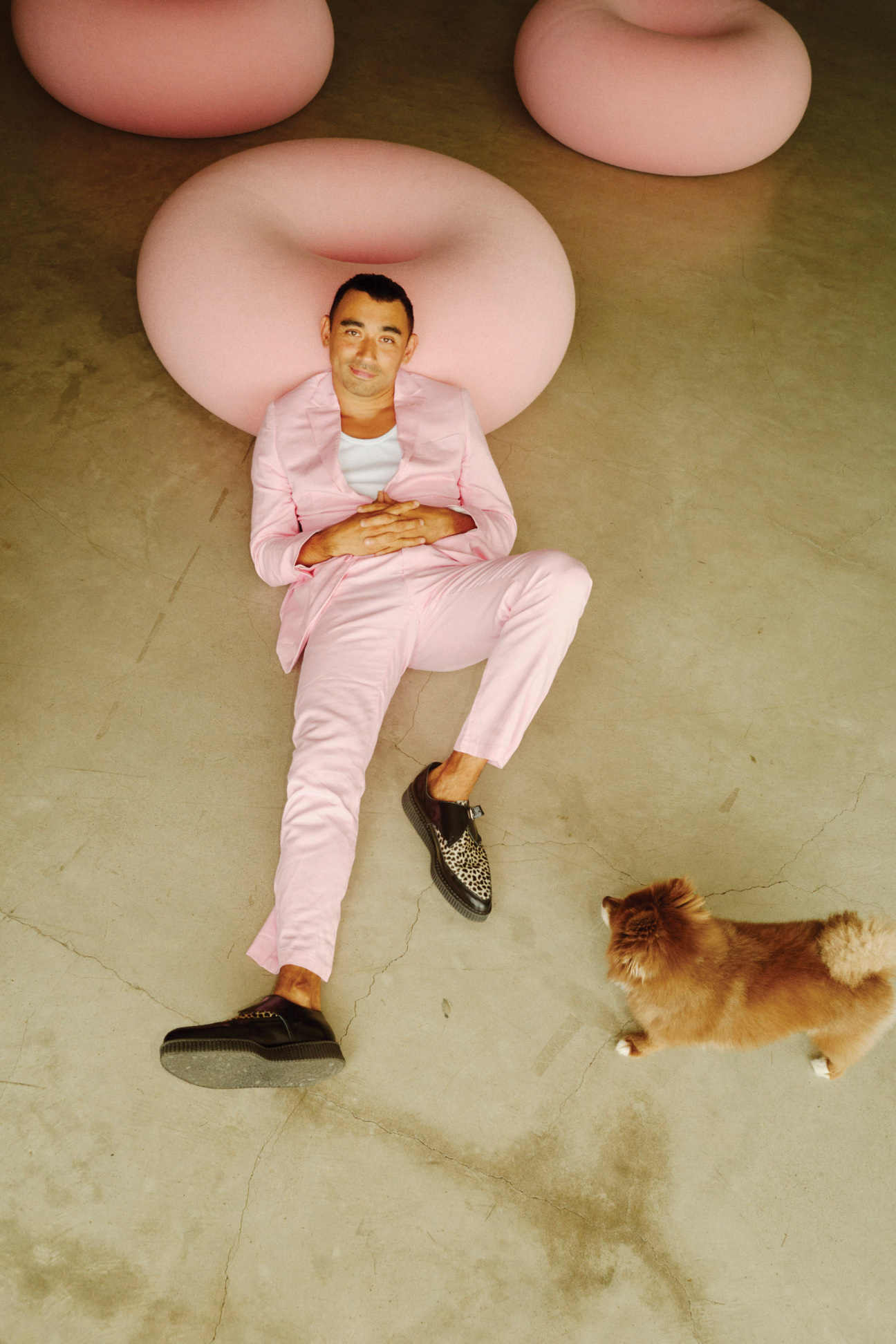 A man lying on the ground with a dog.