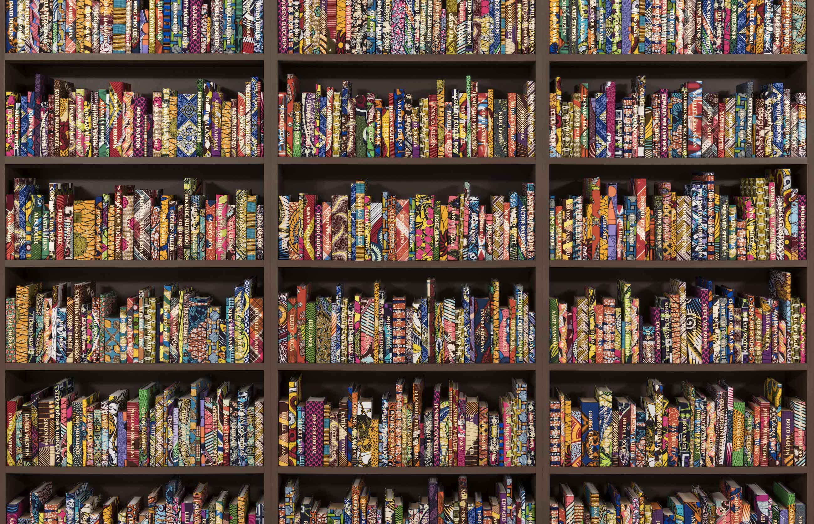 Yinka Shonibare CBE,  British-Nigerian, born 1962, ' The American Library' (2018).  Hardback books, Dutch wax printed cotton textile, gold foiled names, headphones, interactive application.  Installation view at The Cleveland Public Library.  © Yinka Shonibare CBE (RA). Courtesy James Cohan Gallery, New York and FRONT International: Cleveland Triennial for Contemporary Art with funds from VIA Art Fund. Photo ©Field Studio 2018.