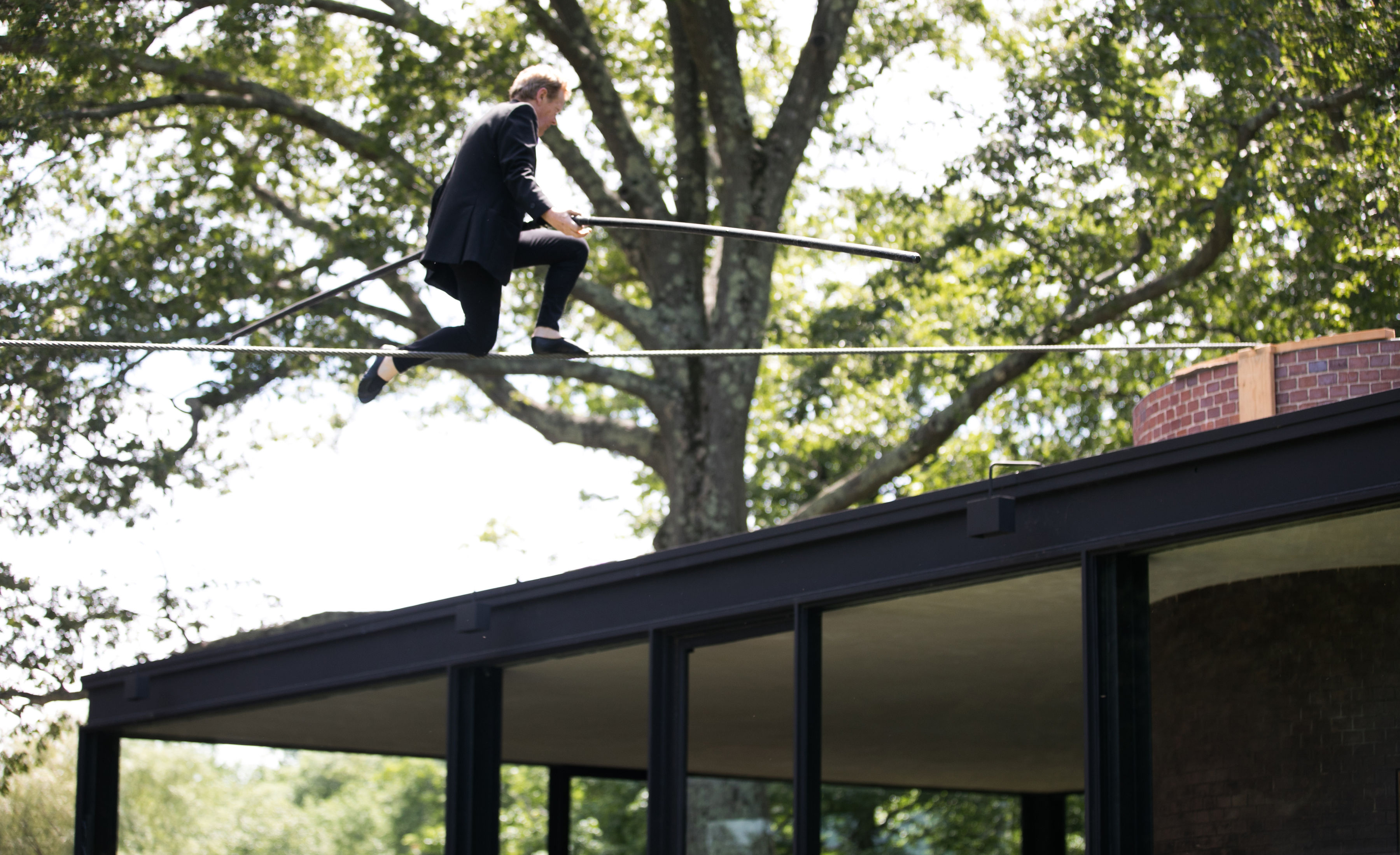 Philippe Petit above the Glass House.