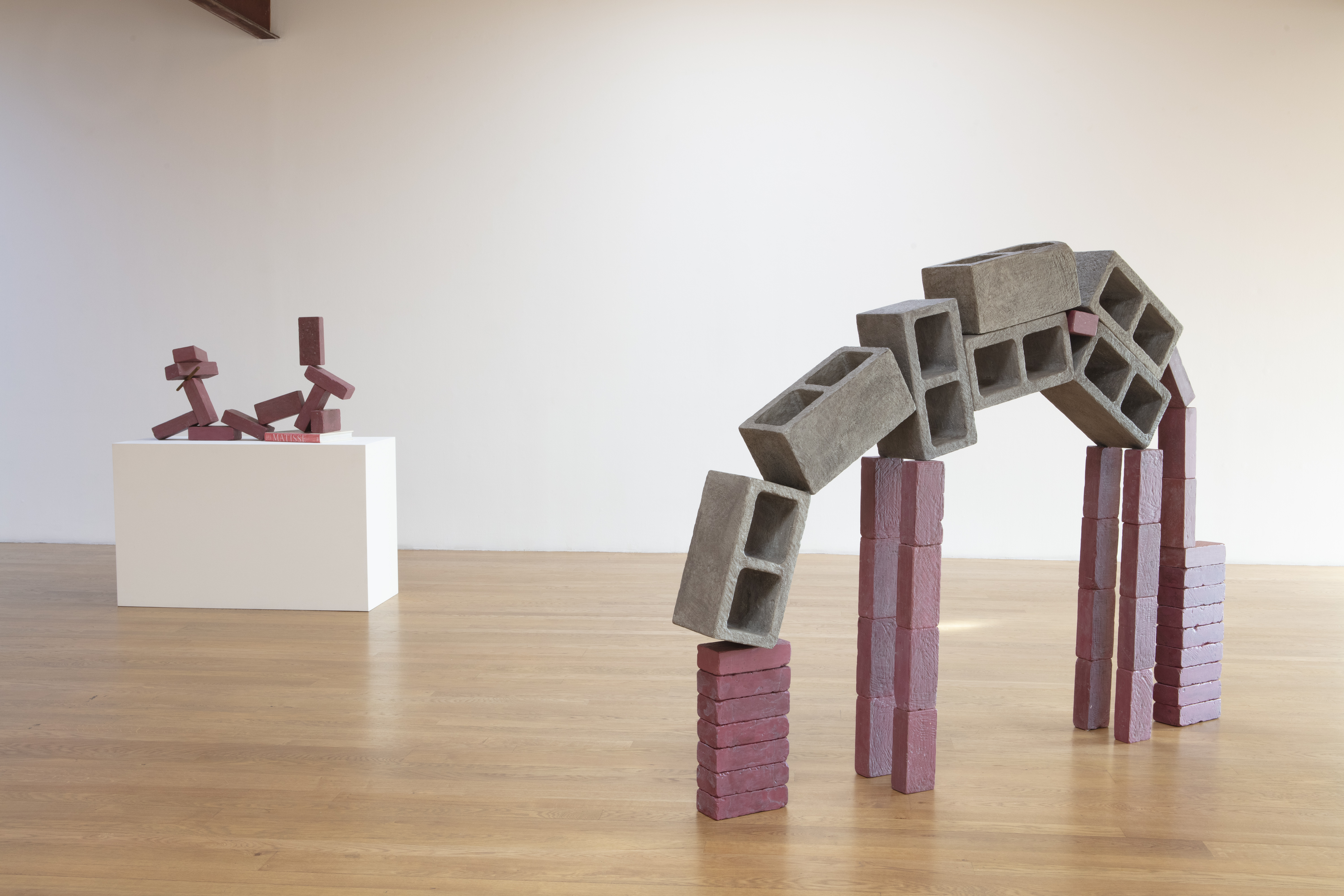 Installation shot featuring 7 block and 36 brick horse and 11 brick reclining figure with 1 bar and a Matisse book. Both works polychromed wood, 2019. Image courtesy Blum & Poe.
