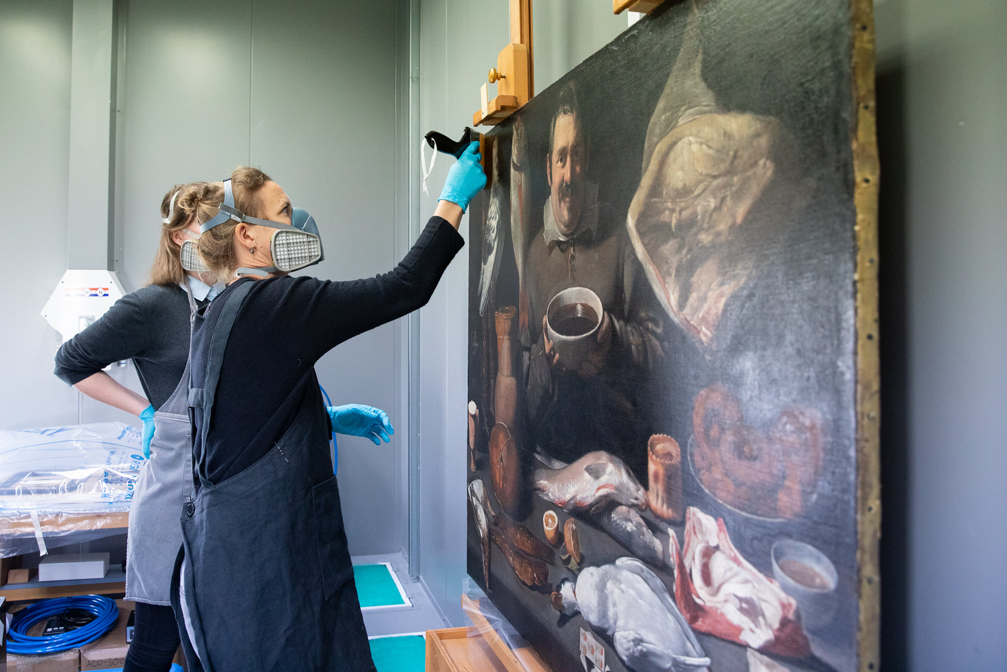 Paintings conservator Anna Krekeler applies a new layer of varnish to improve the depth of the painting Kitchen Scene. Photo courtesy of Rijksmuseum.