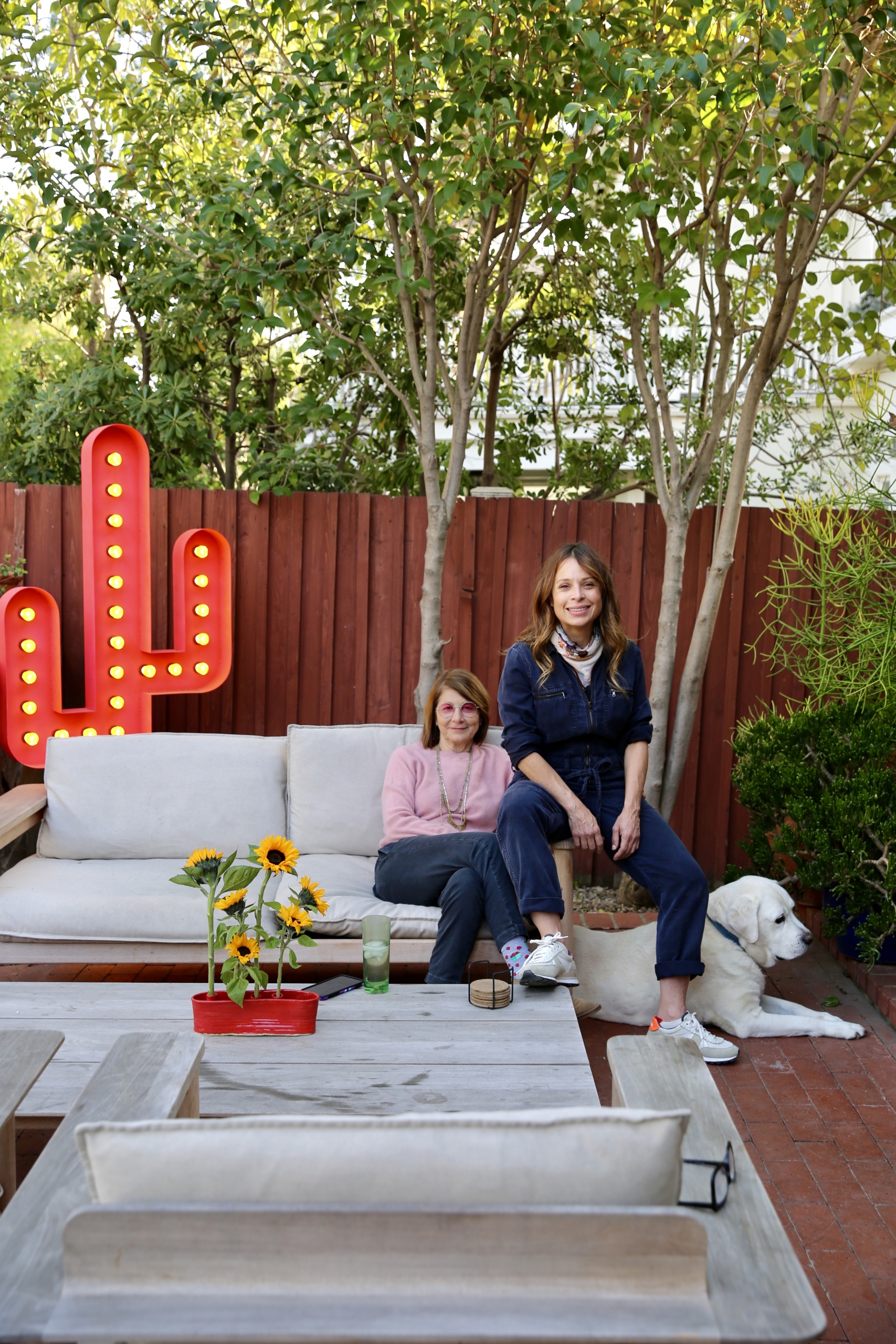 Marisabel Bazan and Lisa Schulte at home with their dog, Desi. Cactus artwork by Schulte.