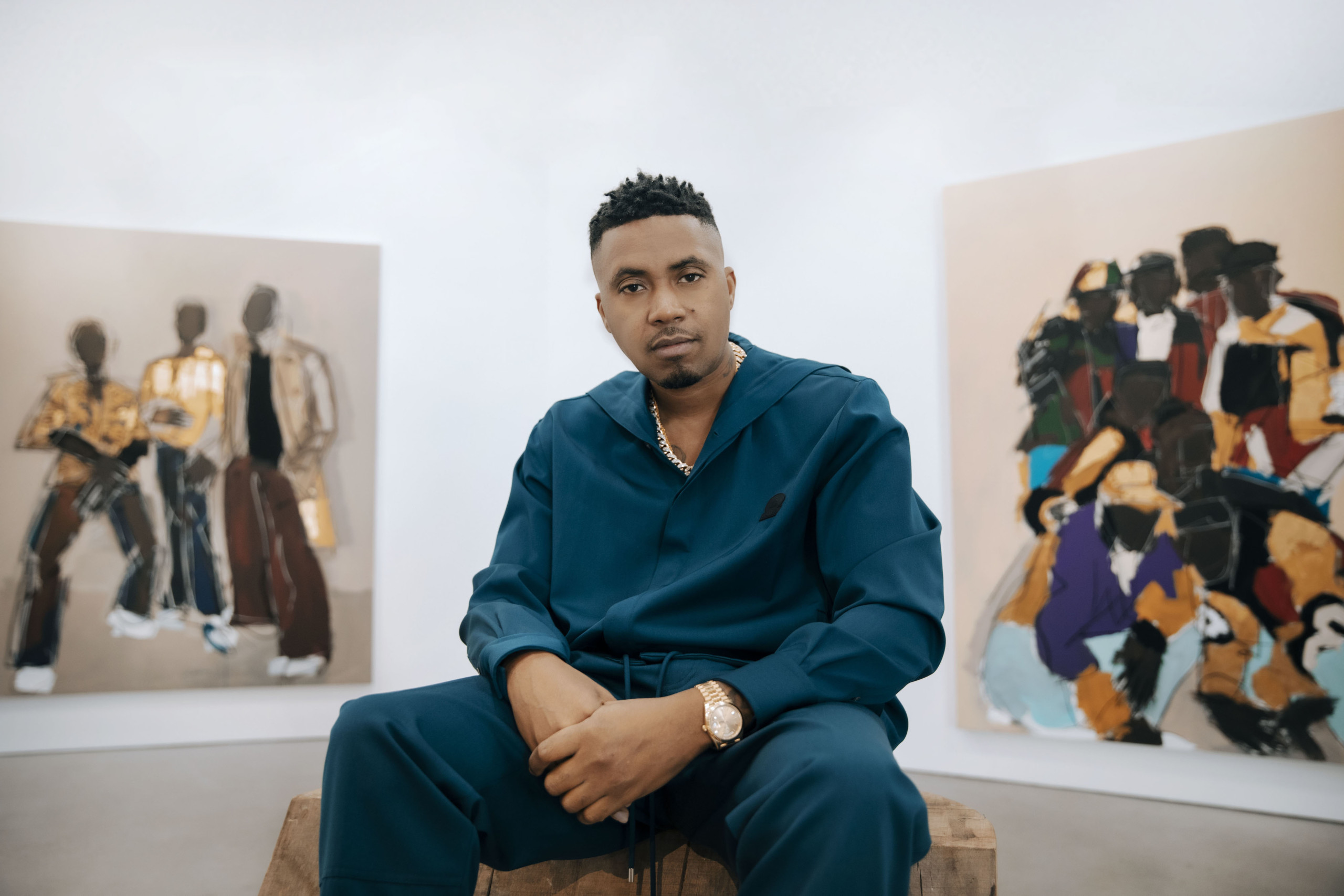 Musician sitting in gallery space, in front of 2 paintings