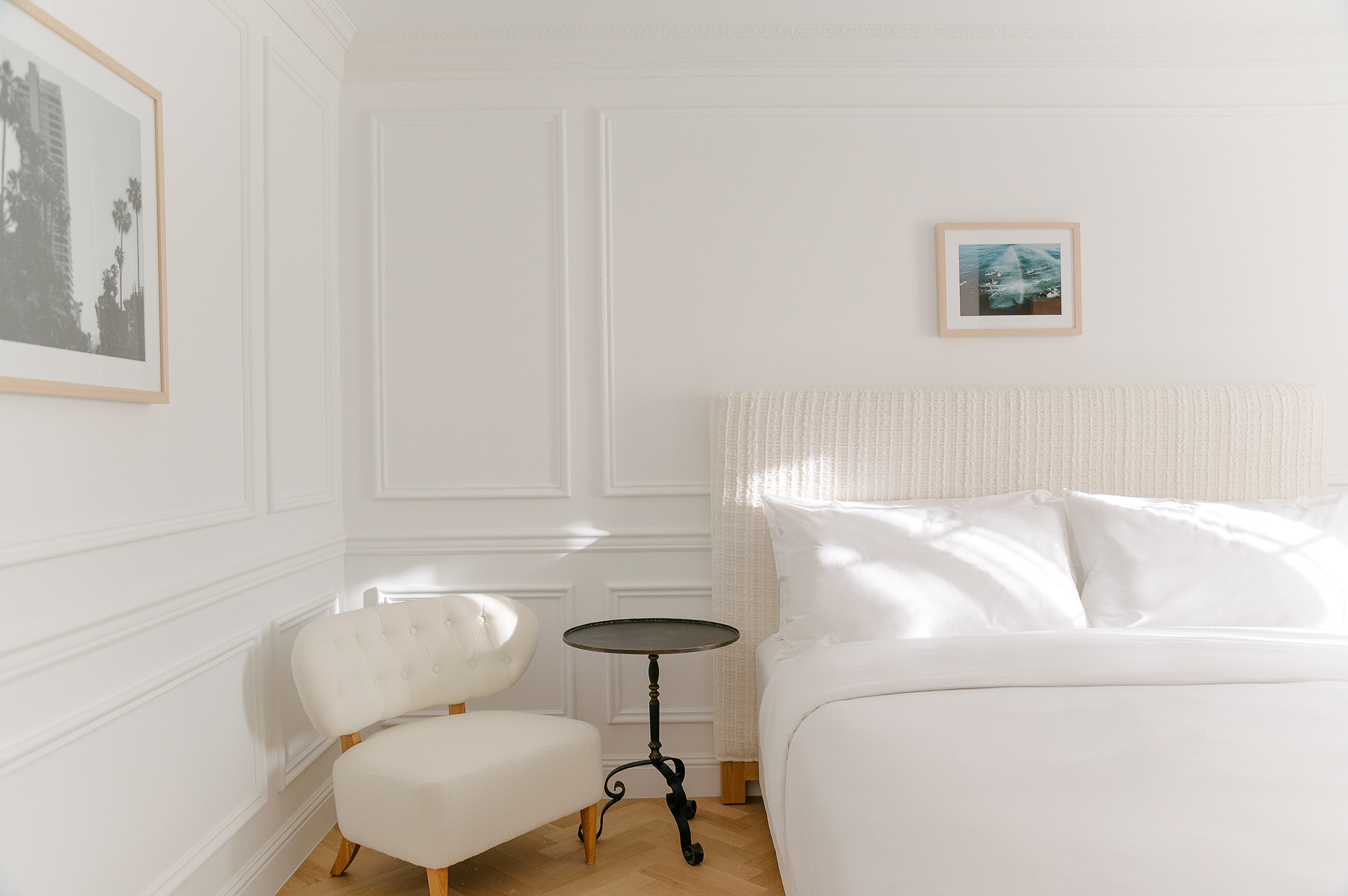 simple hotel bedroom with clean linens and simple chair