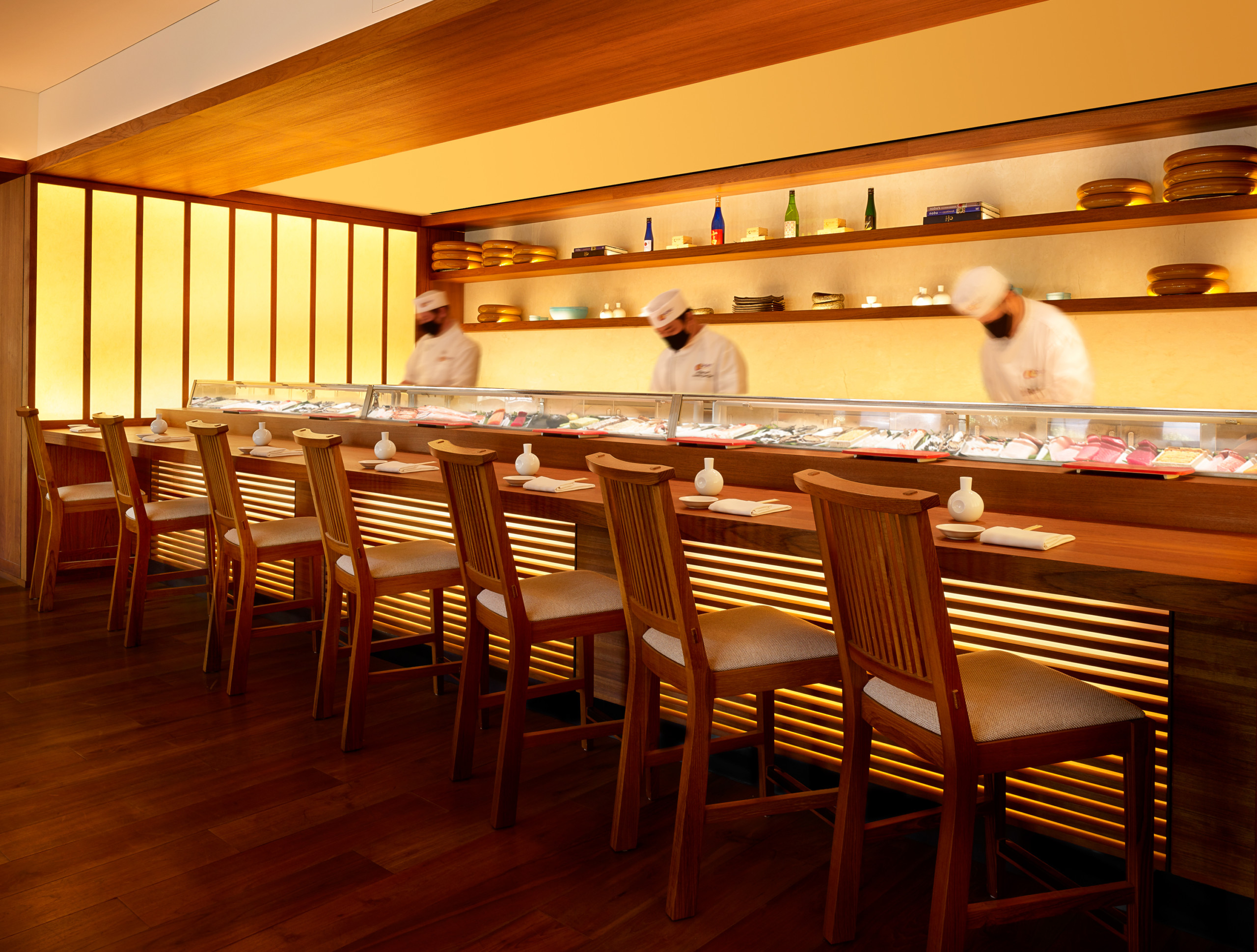 Chefs in action at the hotel restaurant, working behind a seated bar set up. Nobu Hotel Palo Alto